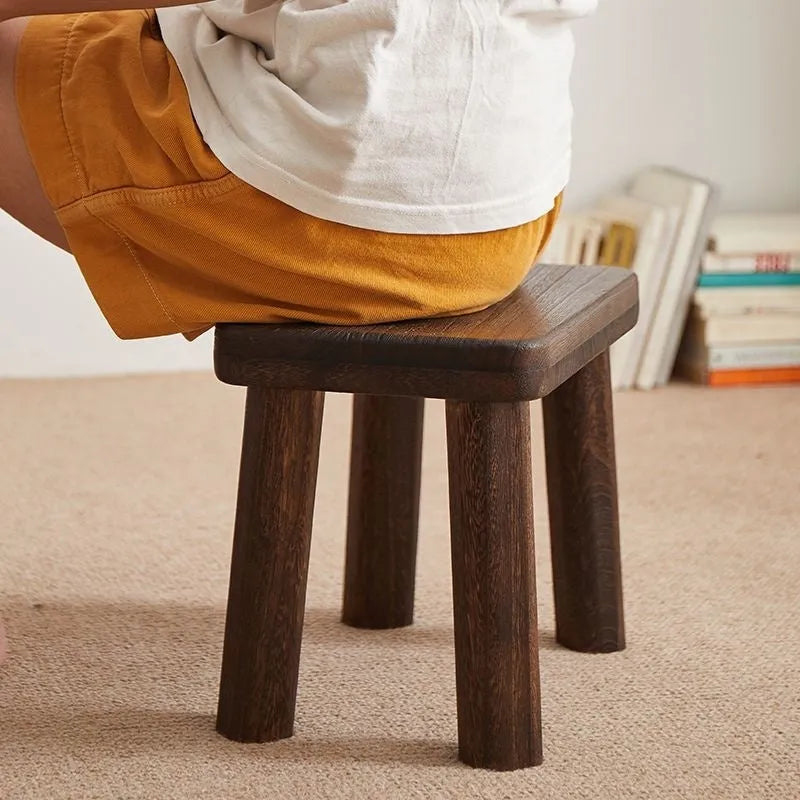 Distressed finish wooden shoes changing stool with bracket construction legs.