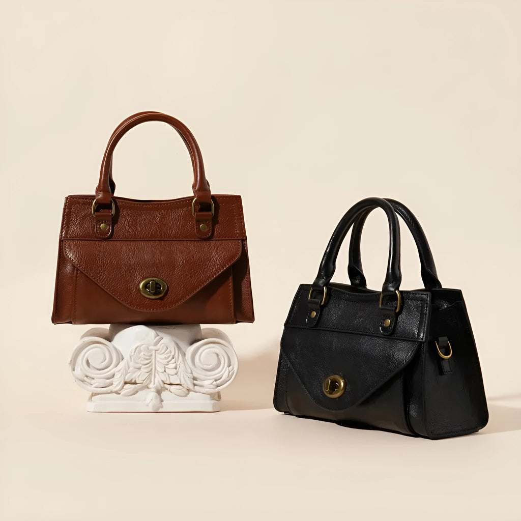 Genuine leather one-shoulder crossbody bag in solid colour with lock closure, horizontal square shape, and visible sewing thread details.