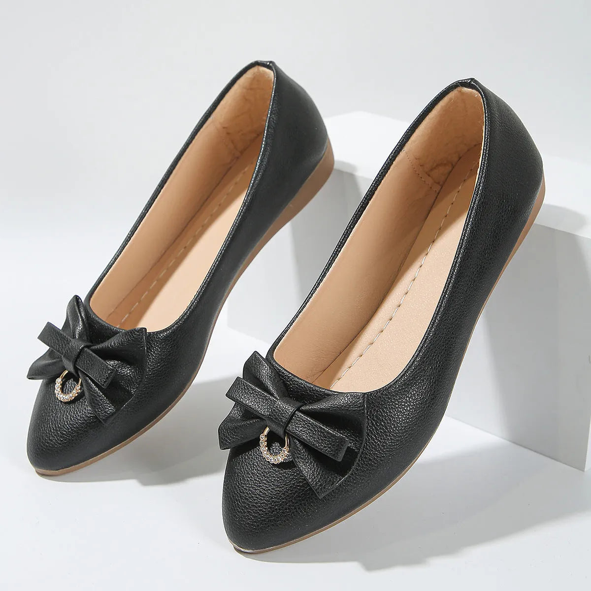 Women's beige casual flat slip-on shoe with a bowknot and round toe on a rubber sole.