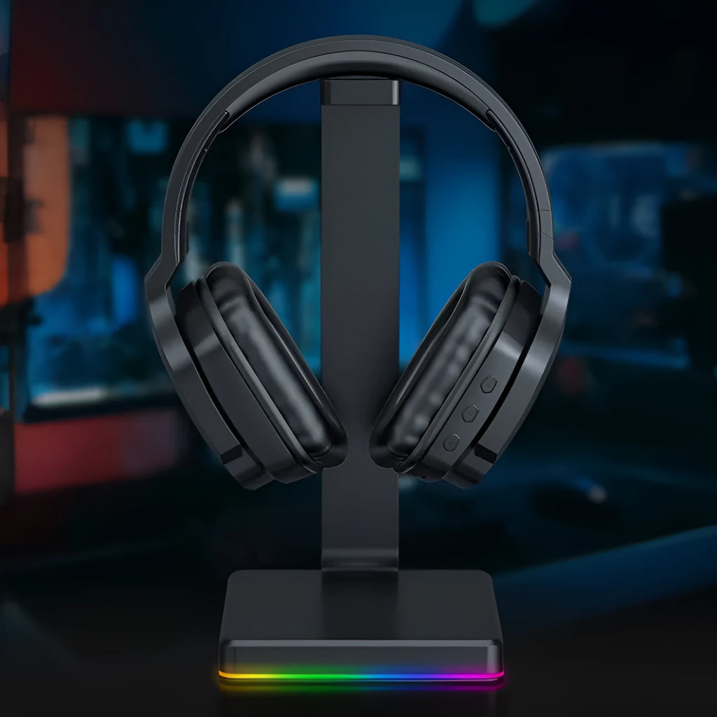 Luminous black wireless head-mounted stereo headphones with ear cups and headband on a grey background.