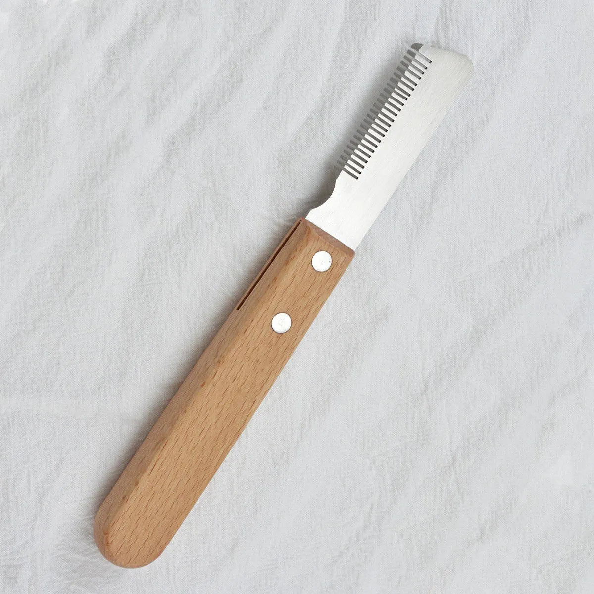 Pet stripping comb grooming tool with wood handle and metal teeth for dogs and cats.