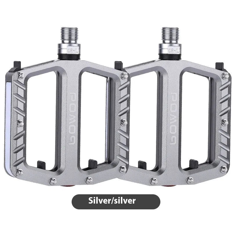 Aluminium alloy bicycle pedals with 710 LED lights in purple, black, titanium, red, and gold colours.