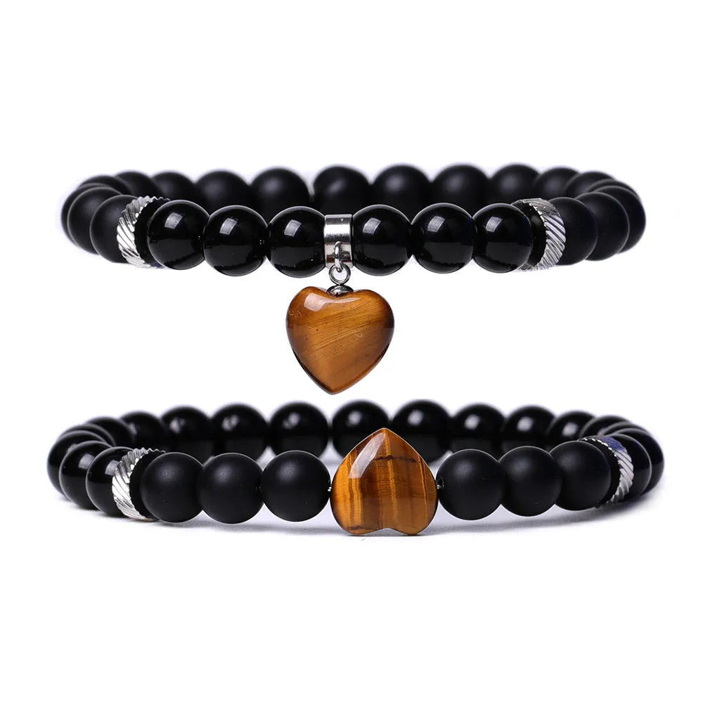 A pair of natural stone heart bracelets for couples on a background, showing geometric polished gemstone designs.