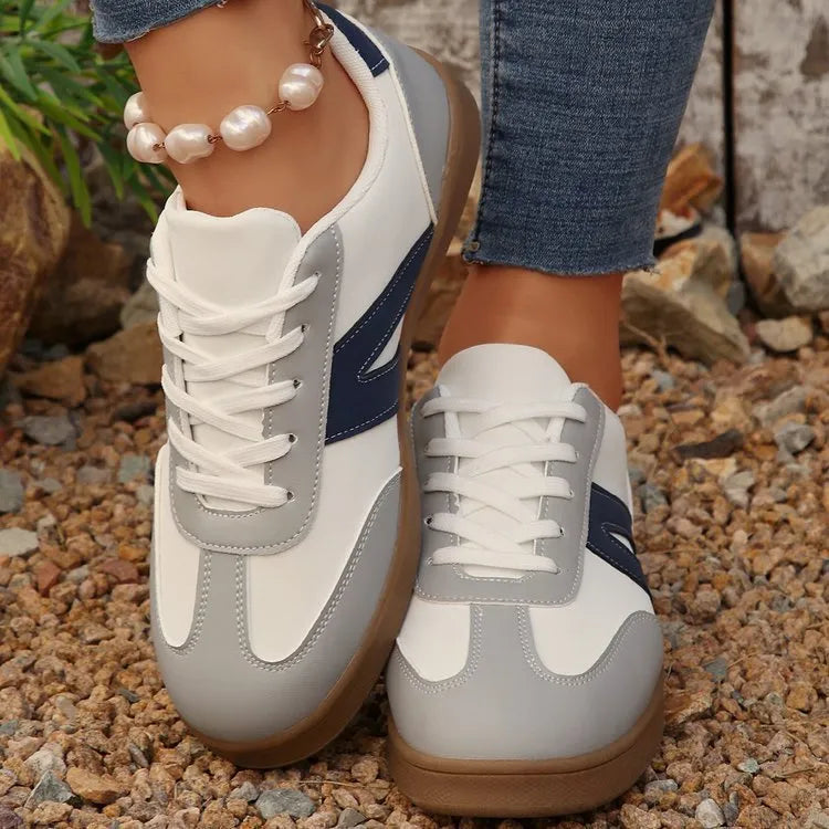 Blue women's low-top hiking shoes with artificial PU upper and rubber sole on a natural background.