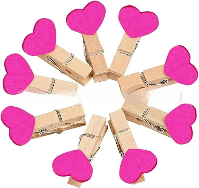 A set of five handmade wooden heart-shaped clips in assorted colours on a plain background.