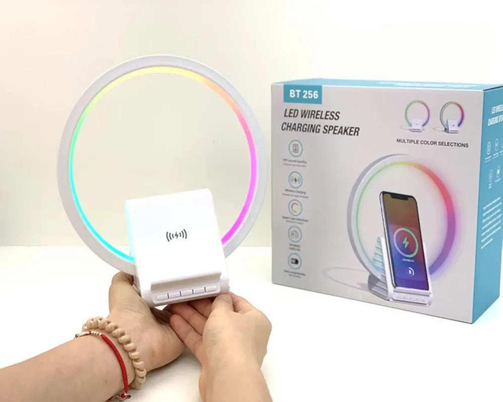White portable Bluetooth speaker with integrated wireless charging pad and ambient lighting.