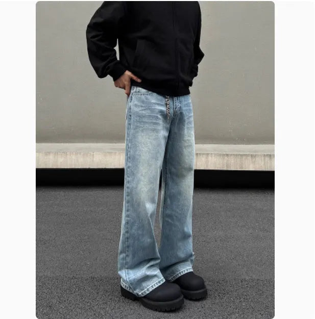 Man wearing blue straight leg jeans with whisker wash detailing and a flared leg style.