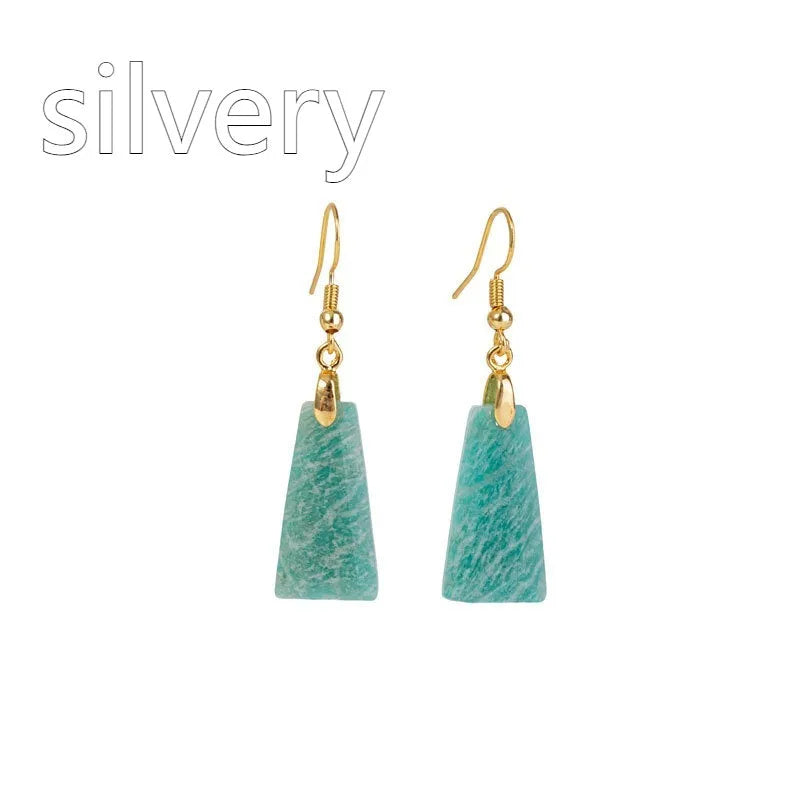 A pair of trapezoid-shaped rough amazonite earrings on a gold and silver background.