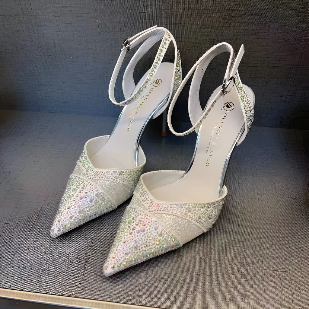 Women's black hollow high heels with red sole and stiletto heel on a plain background.