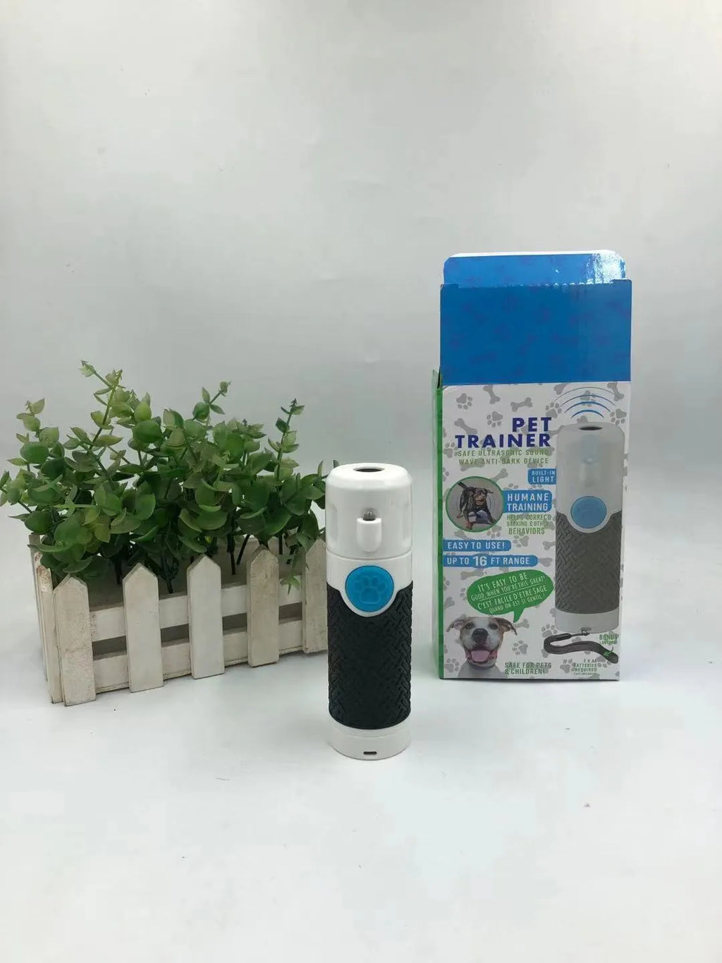 White handheld ultrasonic dog bark training device on a white background.