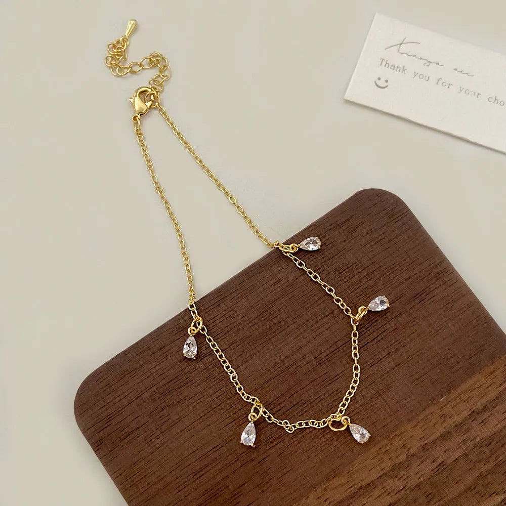 Women's zircon jewellery set showing necklace, earrings and anklet with geometric meteor shower design