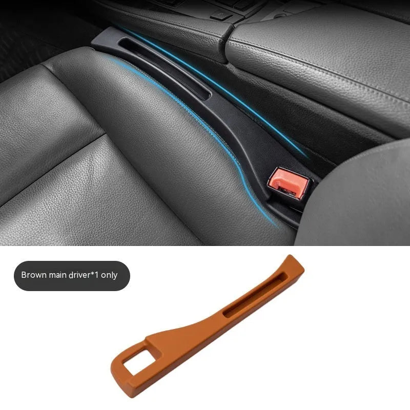 Black plastic car seat gap storage organiser box with a handle, shown inserted between vehicle seats.