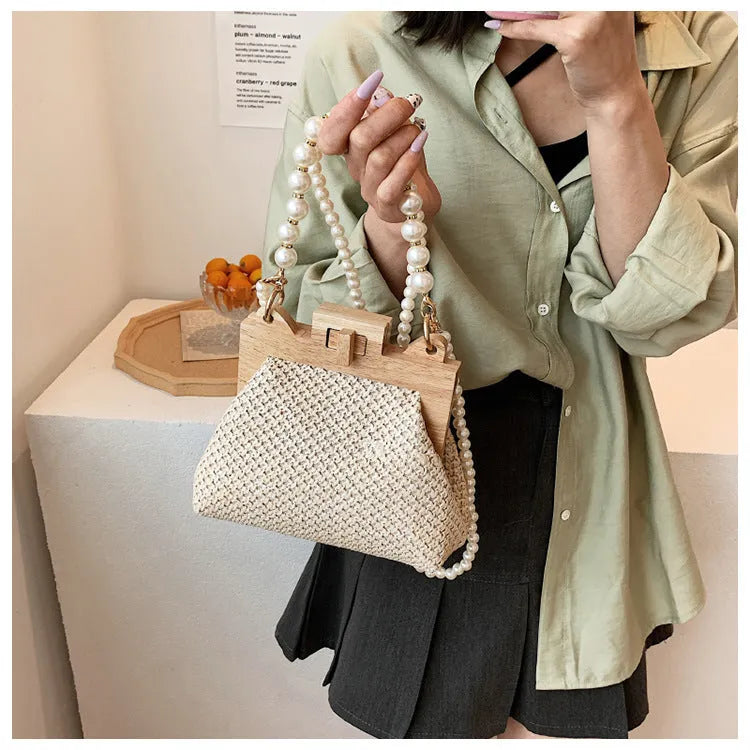 Beige straw woven women's shoulder bag with pearl chain strap showing front view