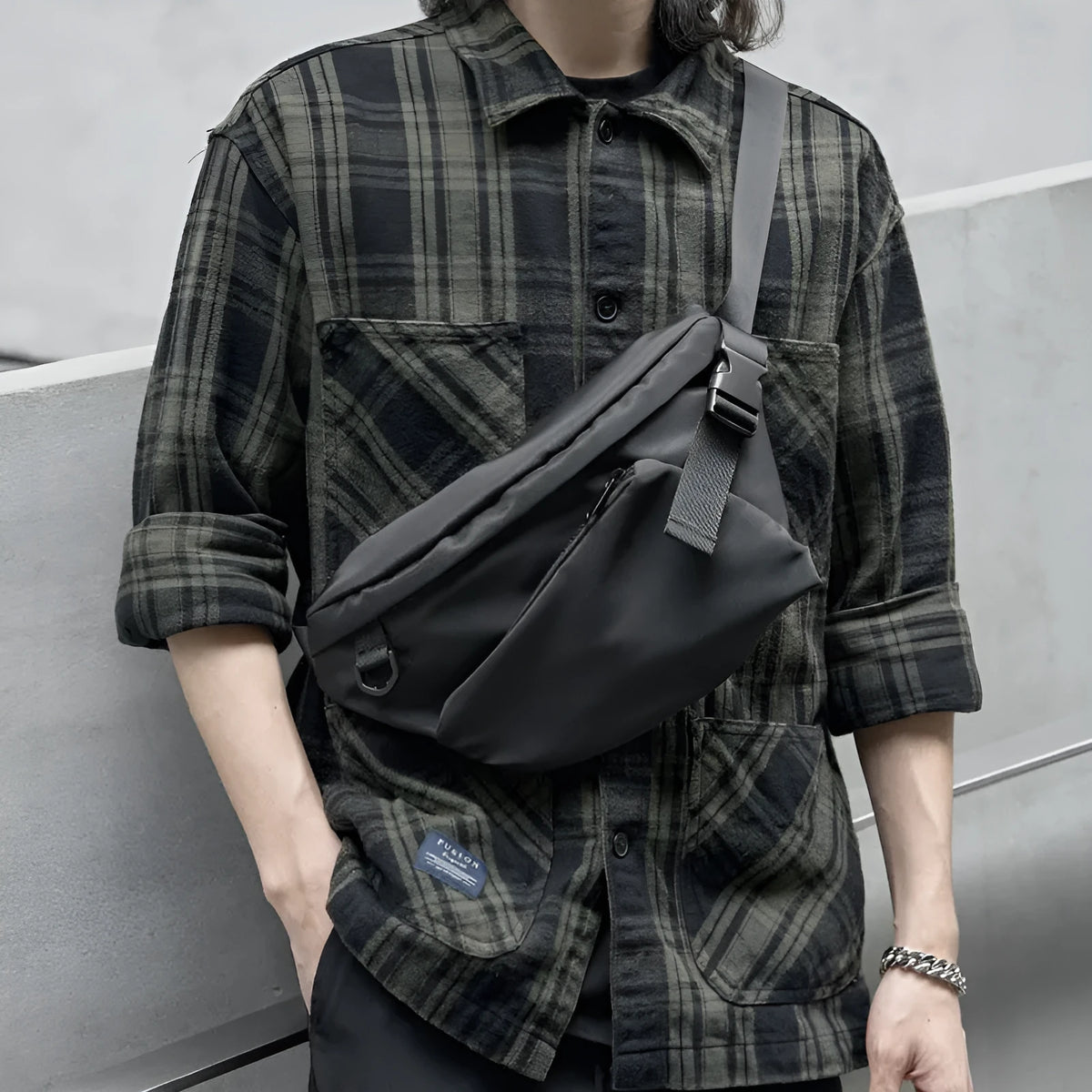 Black men's Oxford fabric chest bag with visible stitching, worn across the chest.
