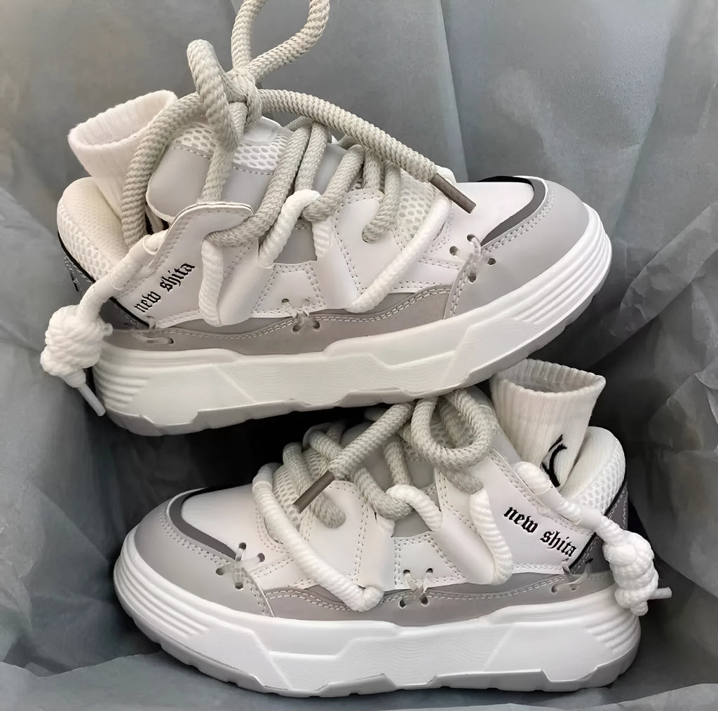 Grey women's chunky retro platform sneakers with thick rubber sole and lace-up front.