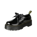 Black thick soled women's lace-up shoes with ribbon and cross strap details on a white background.