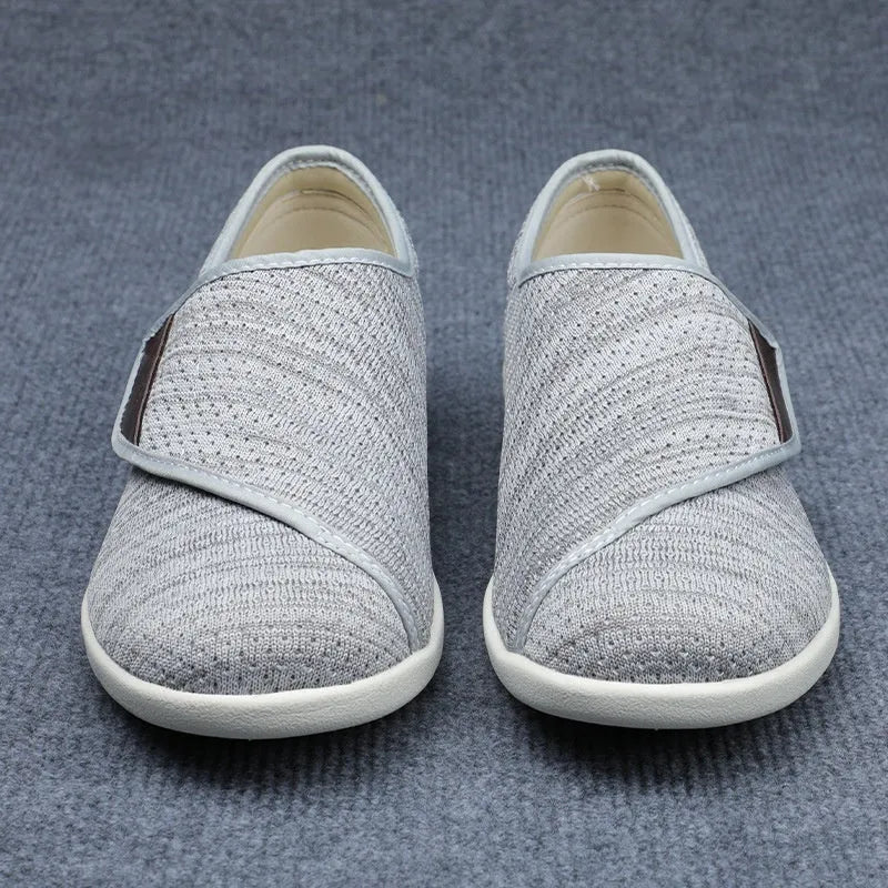 Beige wide-fit leisure shoes with velcro strap and rubber foam sole on a neutral background.