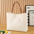 Heavy-duty natural cotton canvas tote bag with flat base and long handles in beige white colour.