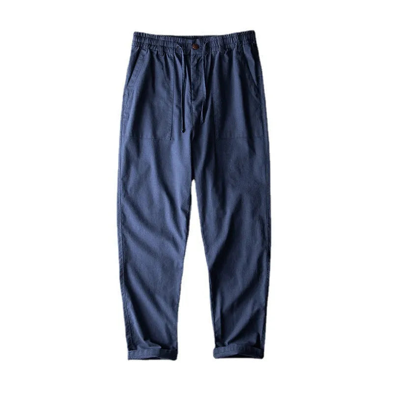 Man wearing solid-colour linen casual trousers in a relaxed setting.