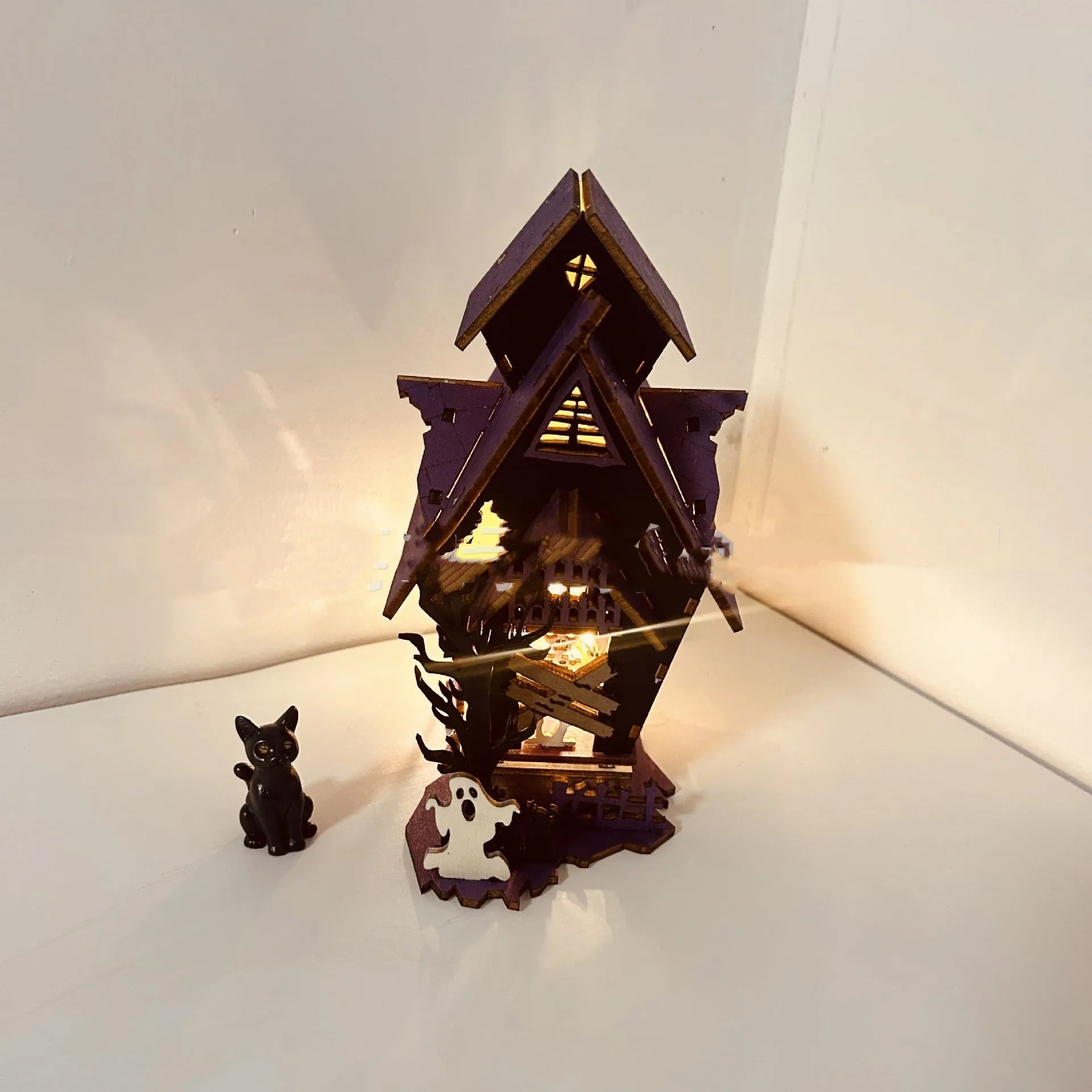 Wooden glowing haunted house Halloween table decoration with candlestick holder function.