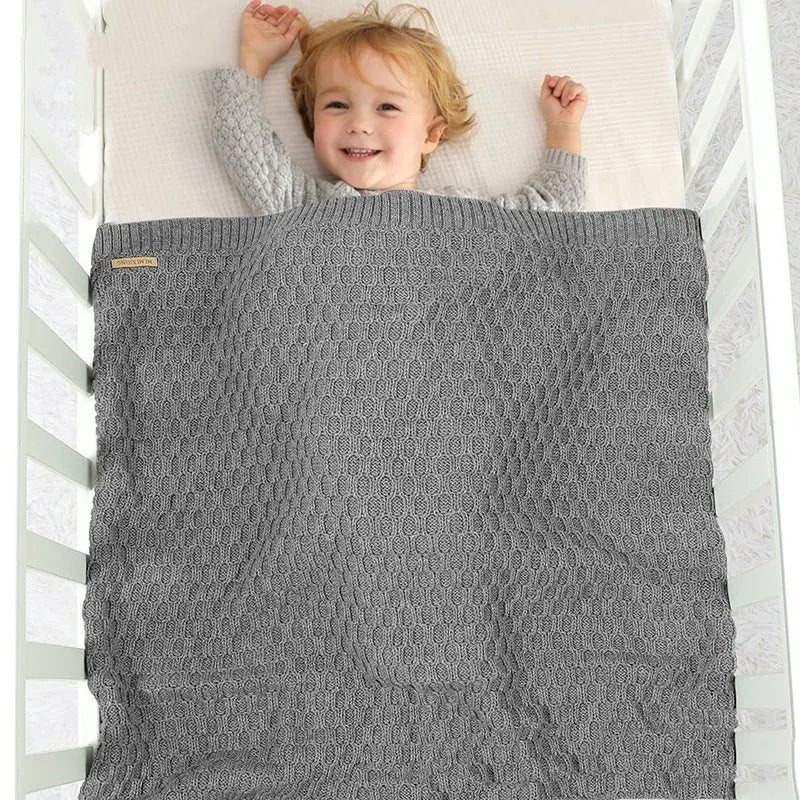 Solid colour acrylic infant hug blanket with three-dimensional lines, shown in a selection of colours.