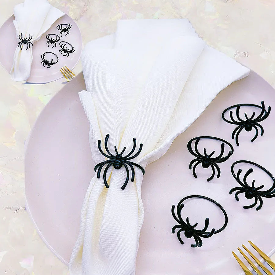 Six black alloy spider-shaped napkin rings for Halloween table decoration.