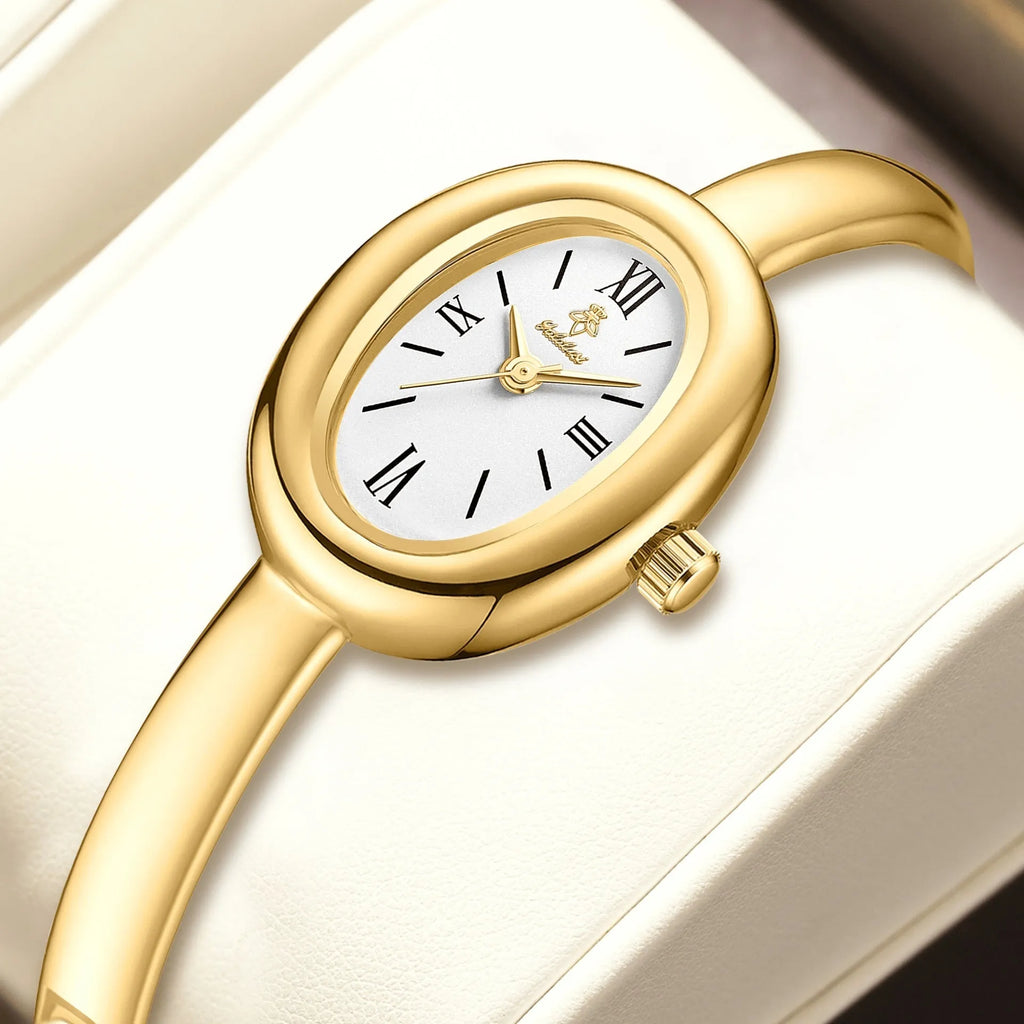 Women's gold and silver oval retro quartz watch with spiral pattern dial options on wrist.